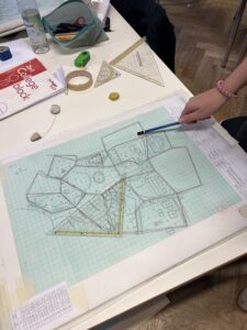 Mit Lineal, Geodreieck und Zirkel werden die Messpunkte maßstäblich zu einer Karte